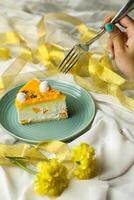 Mango Yogurt Cake slice topping with pistachio fork and flowers served in plate isolated on napkin side view cafe bake food photo