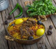 Meat Machboos biryani served in a dish side view on wooden table background photo