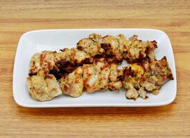 Spicy bbq chicken malai tikka boti kabab served in a dish isolated on grey background side view of indian, pakistani food photo