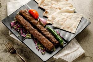 Cordero brocheta plato con un pan servido en un plato aislado en gris antecedentes lado ver rápido comida foto