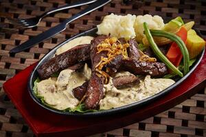 filete con hierba salsa elegante carne de vaca servido en plato aislado en mesa lado ver de medio este comida foto