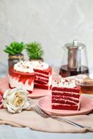 Premium Red Velvet cake and slice include cream, sugar with fork, cup of coffee and pot served on board isolated on napkin side view of cafe food photo