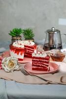 Premium Red Velvet cake and slice include cream, sugar with fork, cup of coffee and pot served on board isolated on napkin side view of cafe food photo