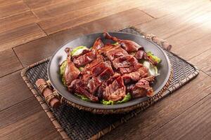 Spicy chilli Hunan style salted duck served dish isolated on wooden table top view of Hong Kong food photo