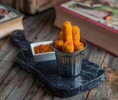 deep-fried cheese finger served in a dish isolated on wooden background side view of appetizer photo