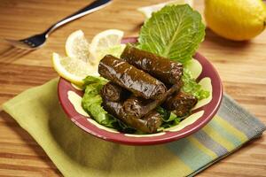 Vine Leaves rolls with lemon slice served in dish isolated on table side view of middle east food photo