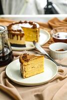 Salted Caramel Blondie cake slice include chocolate cream, sugar with fork, cup of coffee and pot served plate isolated on napkin side view of cafe food photo