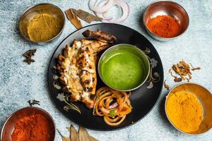 Arabian Tandoori chicken with chili sauce served in a dish isolated on grey background top view of bangladesh food photo