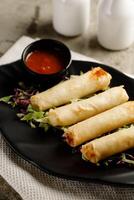 Vegetable Spring Roll with chili sauce served in a dish isolated on grey background side view fast food photo