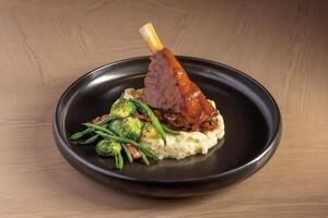 Lamb Shank with mashed potato and salad served in dish isolated on table top view of thai food photo
