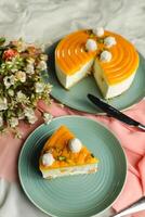 Mango Yogurt Cake slice topping with pistachio fork and flowers served in plate isolated on napkin side view cafe bake food photo