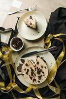 Oreo Cheesecake slice include chocolate, cream, sugar with fork and flowers served in plate isolated on napkin top view of cafe food photo