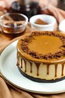 Salted Caramel Blondie cake include chocolate cream, sugar with fork, cup of coffee and pot served on board isolated on napkin side view of cafe food photo