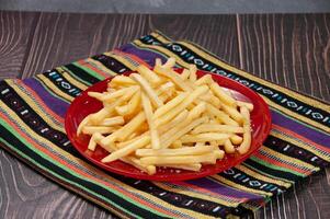 Plain Fries served in a dish isolated on napkin side view on dark background photo