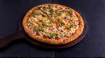 Hot and Sour Chicken pizza isolated on cutting board top view on dark background italian fast food photo