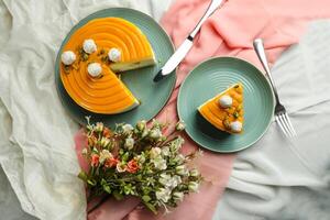 Mango Yogurt Cake slice topping with pistachio fork and flowers served in plate isolated on napkin top view cafe bake food photo
