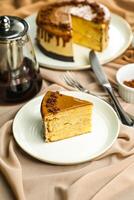 Salted Caramel Blondie cake slice include chocolate cream, sugar with fork, cup of coffee and pot served plate isolated on napkin side view of cafe food photo