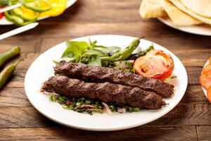 carne de vaca brocheta con ensalada servido en un plato aislado en de madera mesa antecedentes lado ver de comida rápida foto