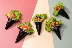 Assorted japanese wraps Spicy TAMAGO, CALIFORNIA wrap, POKE SALMON Skin, SPICY TUNA roll topping with salad leaves isolated on sky blue background top view fast food photo