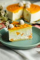 Mango Yogurt Cake slice topping with pistachio fork and flowers served in plate isolated on napkin side view cafe bake food photo
