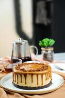 Salted Caramel Blondie cake include chocolate cream, sugar with fork, cup of coffee and pot served on board isolated on napkin side view of cafe food photo