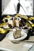 Oreo Cheesecake slice include chocolate, cream, sugar with fork and flowers served in plate isolated on napkin side view of cafe food photo
