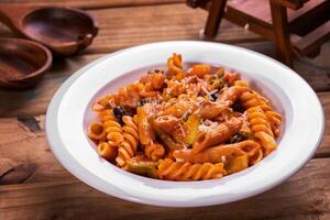 Red pasta served in dish top view on dark background american fast food photo