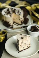 Oreo Cheesecake slice include chocolate, cream, sugar with fork and flowers served in plate isolated on napkin side view of cafe food photo