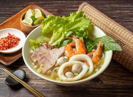 Seafood Pho with squid and shrimp served in bowl isolated on table top view of taiwan food photo