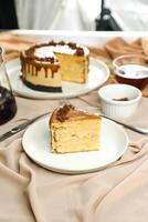 Salted Caramel Blondie cake slice include chocolate cream, sugar with fork, cup of coffee and pot served plate isolated on napkin side view of cafe food photo