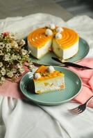 Mango Yogurt Cake slice topping with pistachio fork and flowers served in plate isolated on napkin side view cafe bake food photo