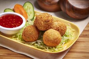 Fried Cheese Balls with chili sauce and salad served in dish isolated on table side view of middle east food photo