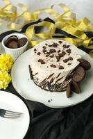 Oreo Cheesecake include chocolate, cream, sugar with fork and flowers served in plate isolated on napkin side view of cafe food photo