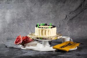 Blueberry White Cake fresh cream with rose flowers, knife and fork served on board isolated on napkin side view of cafe baked food photo