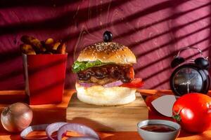 BBQ chicken cheese burger with french fries, potato and tomato slice isolated on wooden board side view on table fast food photo