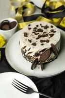 Oreo Cheesecake include chocolate, cream, sugar with fork and flowers served in plate isolated on napkin side view of cafe food photo