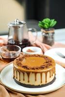 Salted Caramel Blondie cake include chocolate cream, sugar with fork, cup of coffee and pot served on board isolated on napkin side view of cafe food photo