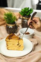 Salted Caramel Blondie cake slice include chocolate cream, sugar with fork, cup of coffee and pot served plate isolated on napkin side view of cafe food photo