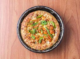 Chicken Fajita Pizza isolated on wooden background, spiced chicken cubes and cheese combination on bread, Italian food top view photo