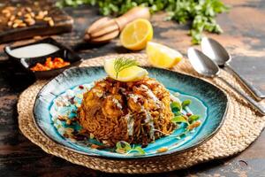 Machboos Prawns biryani rice with lemon slice served in dish isolated on table top view of arabic breakfast photo