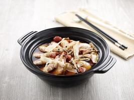 with chopsticks served in a claypot isolated on mat side view on grey background photo