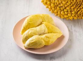 Golden Pillow Tree Ripe Durian with raw fruits served in disposable glass isolated on background top view taiwan food photo