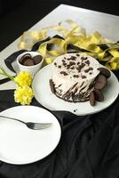 Oreo Cheesecake include chocolate, cream, sugar with fork and flowers served in plate isolated on napkin side view of cafe food photo