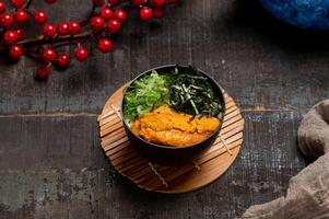 Sea Urchin Chawanmushi in a dish with chopsticks isolated on mat side view on wooden table taiwan food photo