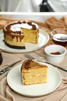 Salted Caramel Blondie cake slice include chocolate cream, sugar with fork, cup of coffee and pot served plate isolated on napkin side view of cafe food photo