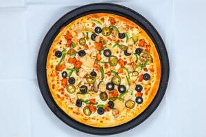 Chicken Fajita Pizza isolated on wooden background, spiced chicken cubes and cheese combination on bread, Italian food top view photo