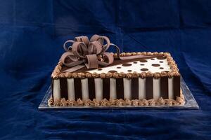 Square Chocolate Cake served on board isolated on napkin side view of cafe baked food photo