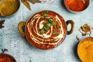 Chicken Tikka Butter Masala with chili sauce served in a dish isolated on grey background top view of bangladesh food photo