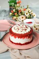 Premium Red Velvet cake include cream, sugar with fork, knife and flowers served in plate isolated on napkin side view of cafe food photo