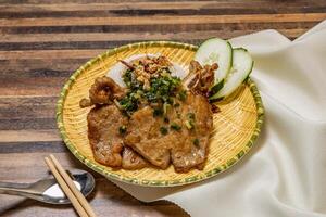 Pork chop curry with rice, cucumber and chopsticks served in dish isolated on wooden table top view of hong kong fast food photo